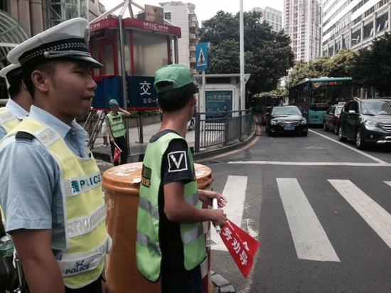 深圳市民闯红灯被罚戴绿帽执勤