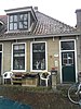 Eenvoudige woning onder hoog zadeldak