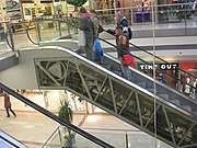 A "freestanding" escalator reveals its inner components through the transparent truss.