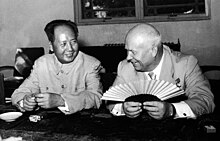 Photographie de deux hommes souriant assis à une table