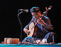 Man is playing the đàn nguyệt.