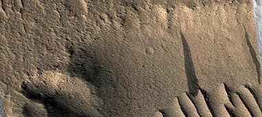 Close view of dark slope streaks on wall of trough as seen by HiRISE under HiWish program. The image is about 1 km across.