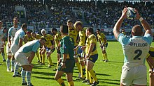 Photographie d'une phase d'un match de rugby, avec en premier plan un joueur de l’Aviron bayonnais rugby pro.