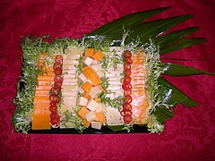 Cheese tray garnished with red pepper rings and chicory