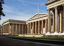 A museum building designed in the Greek Revival style with a flag on top.