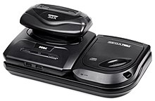 Photo d'une Mega Drive imbriquée dans l'extension Mega-CD, avec le périphérique 32X emboité dans la fente à cartouche de la Mega Drive