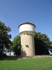 vue du château d'eau qui imite le style quercynois avec une toiture conique en tuiles plates