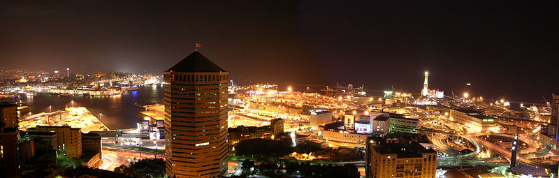 The port of Genoa at night-time, with lights illuminating it.