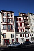 Vue des façades blanches à pans de bois de bâtiments de quatre étages.