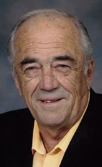 Photo of an elder Badham in dark suit and beige shirt