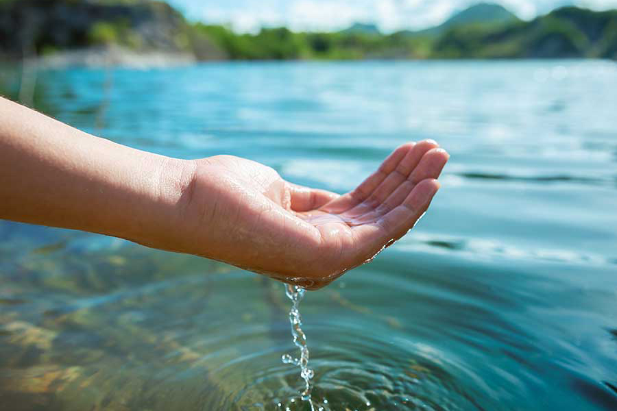 Hand cupping water at a lake