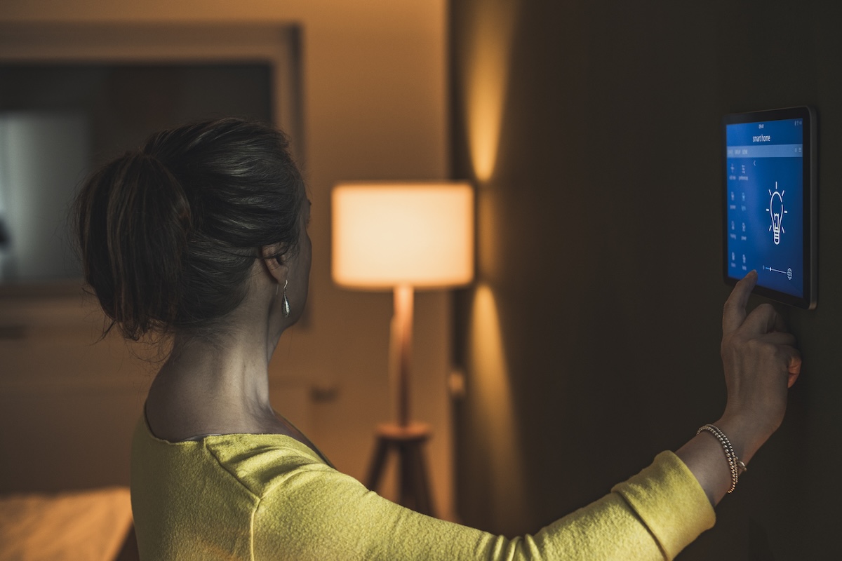 A person dimming a lamp using a smart home hub.