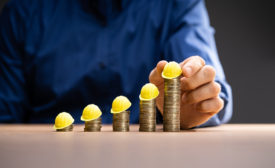 stacks of coins with construction hats