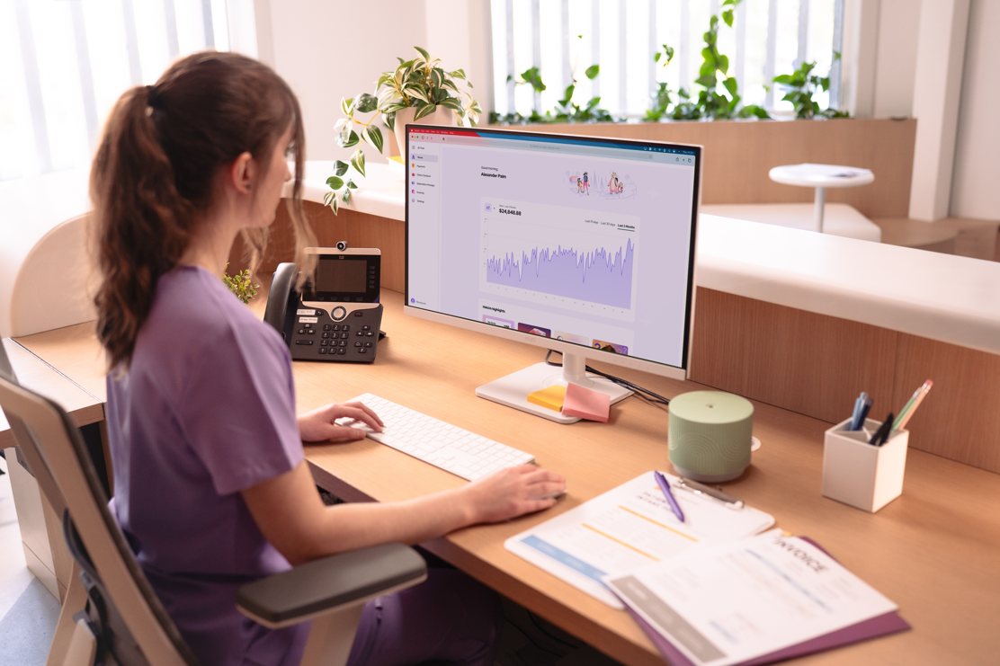 Office professional reviewing Helcim payment dashboard on desktop computer