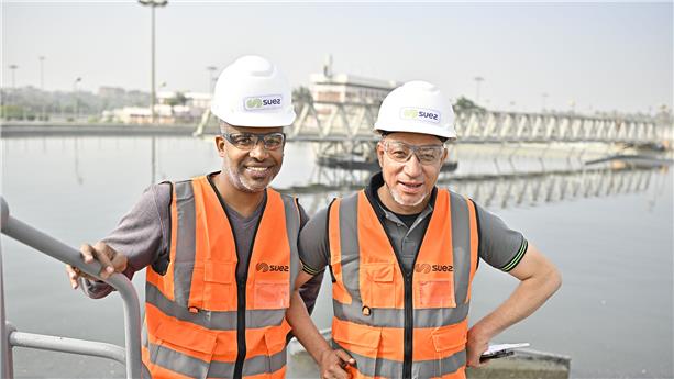 Staff members in front of a water tank at the Gabal El Asfar waste water treatment plant, in Cairo, Egypt