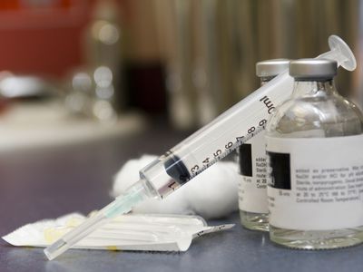 a syringe and two vials of medicine.