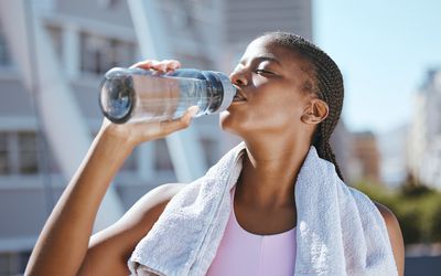 A woman drinking water after exercising