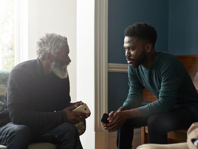 Male friends talking while sitting in living room