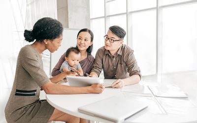 Couple with a baby filling out health insurance paperwork