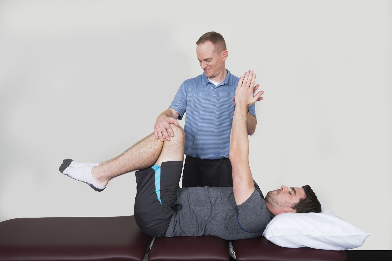 physical therapist assisting man with core exercise