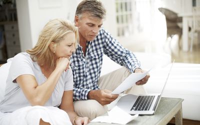 man and woman looking confused over paperwork