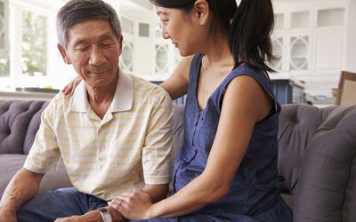 adult daughter comforting her father