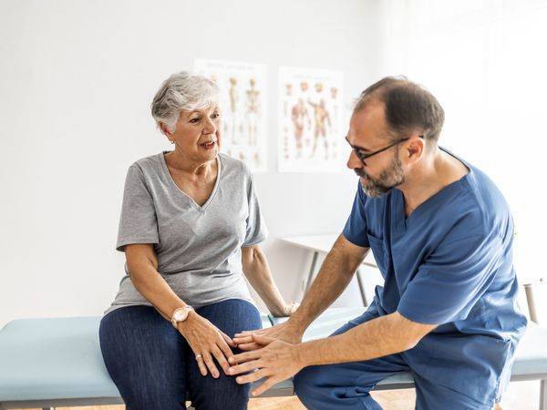 person speaking with healthcare provider about knee pain