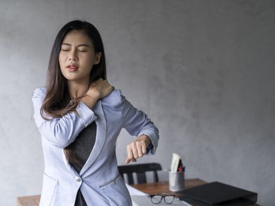 Office syndrome concept.Tired exhausted Asian young businesswoman work hard shoulder pain after working on computer laptop for a long time