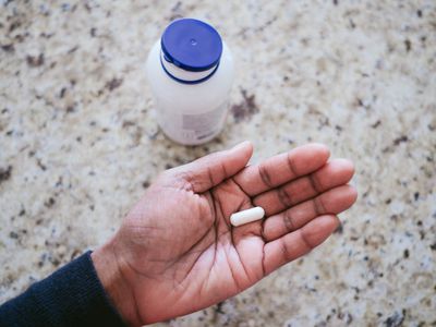 High angle view of unrecognizable hand holding nutritional supplement