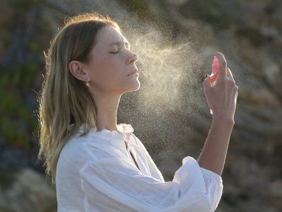 Woman spraying facial mist on her face