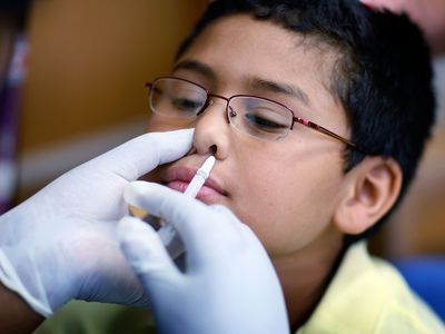 A boy receives nasal flu spray vaccine