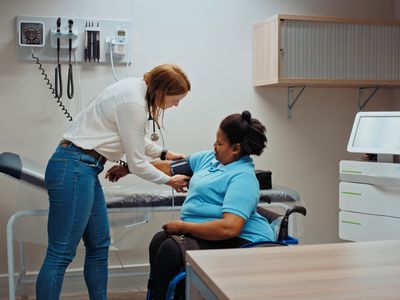 Woman taking patient's blood pressure