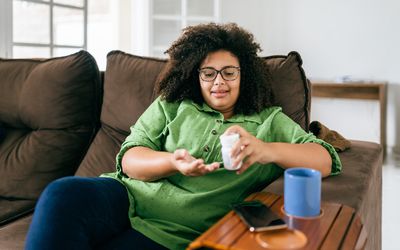 An image of a woman taking medication