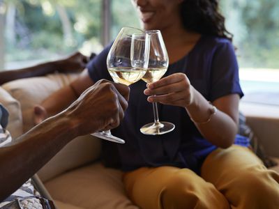 Couple toasting with white wine - stock photo