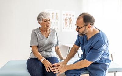 person speaking with healthcare provider about knee pain