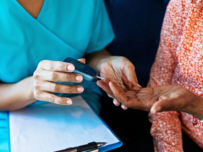 A healthcare provider shows a person with type 2 diabetes how to test their blood sugar.