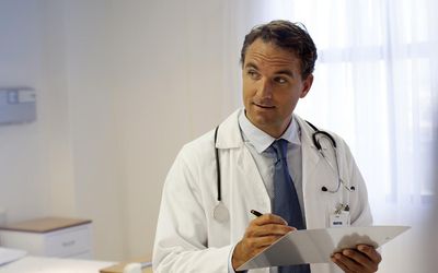 Doctor writing on clipboard in hospital