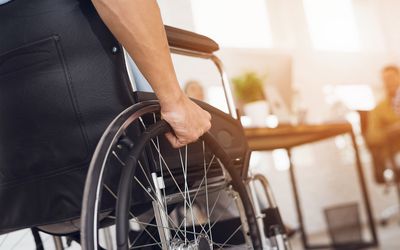 A disabled man is sitting in a wheelchair.