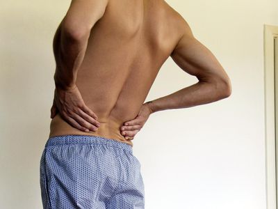 Back and knee pain. Man experiencing lower back pain, croppeds