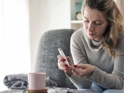 Young woman checking glucose level at home