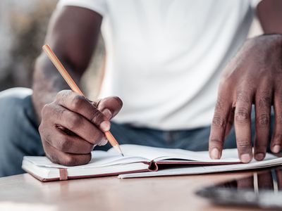 Close up of african american man taking notes - stock photo