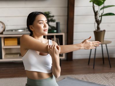 Young woman stretching during cool down after exercising. 