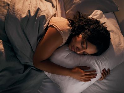 High angle shot of a young woman sleeping in bed