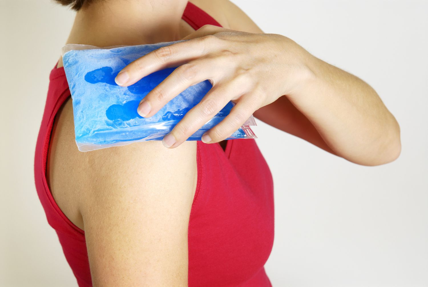 Woman holding ice pack on her shoulder