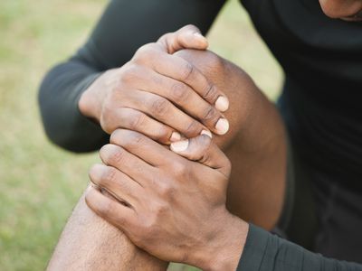 a picture of a man holding injured knee.