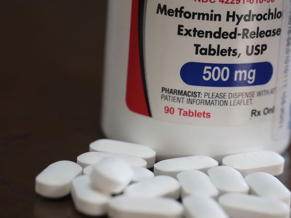 Metformin ER 500 mg tablets in front of a bottle of the medication