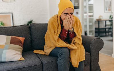 a man sneezing into his hands