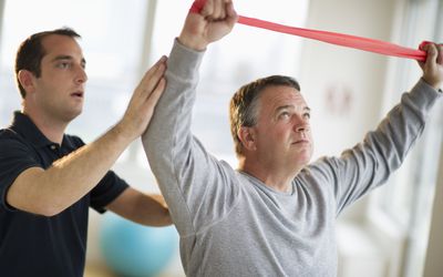 Physical therapist working with man exercising