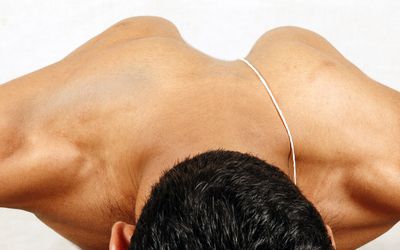 photo of man lying on stomach with shoulder blades protruding