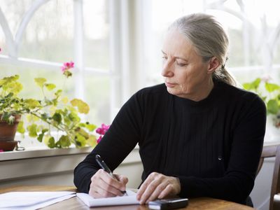 Woman at table writing down thoughts